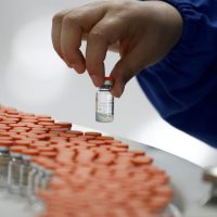 FILE PHOTO: A worker performs a quality check in the packaging facility of Chinese vaccine maker Sinovac Biotech, developing an experimental coronavirus disease (COVID-19) vaccine, during a government-organized media tour in Beijing, China, September 24, 2020. REUTERS/Thomas Peter/File Photo