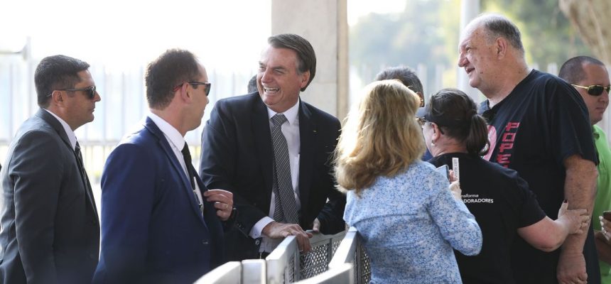 O presidente Jair Bolsonaro, cumprimenta populares  no Palácio da Alvorada