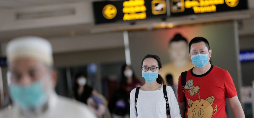 People wearing masks walk at Bandaranaike International Airport after Sri Lanka confirmed the first case of coronavirus in the country, in Katunayake, Sri Lanka January 30, 2020. REUTERS/Dinuka Liyanawatte