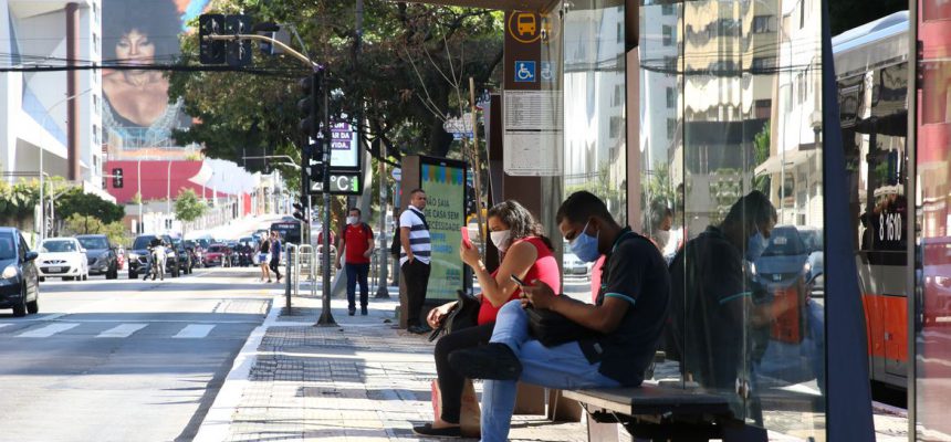 Usuários de transporte público usam máscaras de proteção contra covid-19 em ponto de ônibus na rua da Consolação