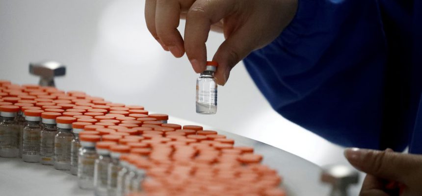 FILE PHOTO: A worker performs a quality check in the packaging facility of Chinese vaccine maker Sinovac Biotech, developing an experimental coronavirus disease (COVID-19) vaccine, during a government-organized media tour in Beijing, China, September 24, 2020. REUTERS/Thomas Peter/File Photo