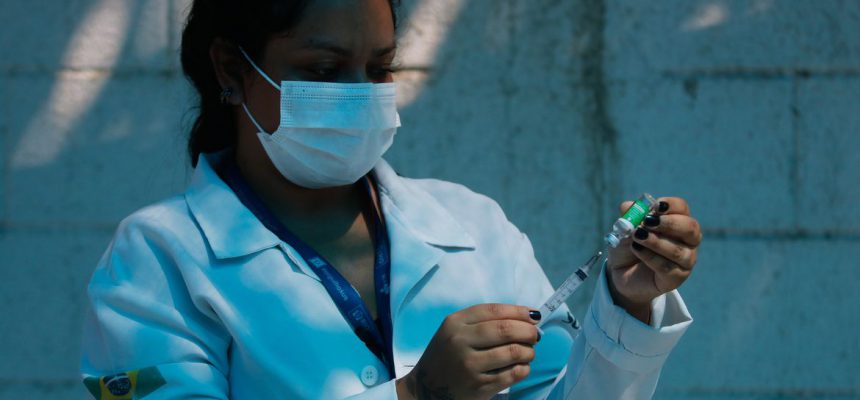 A técnica de enfermagem, Paula Roberta Moreira mostra a ampola da vacina contra a covid-19 antes de aplicar a injeção. Vacinação dos profissionais de saúde, veterinários e agentes funerários com 60 anos ou mais de idade, que estam na ativa, na Clínica da Família Estácio de Sá, na região central da cidade. O município do Rio de Janeiro ampliou hoje (27) o público-alvo da campanha de vacinação contra a covid-19.